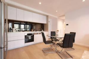a kitchen with a glass table and black chairs at Modern 2BR nr Yara river, city view, Free parking in Melbourne