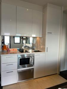 a kitchen with white cabinets and a stainless steel appliance at Lovely 2-bedroom apartment, breathtaking view! in Frankston