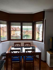 a dining room with a table and chairs and windows at Apartamento Playa de Usil in Mogro