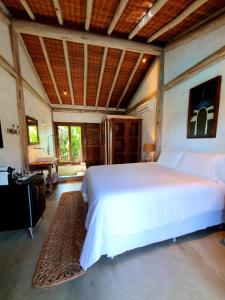 1 dormitorio con 1 cama blanca grande y escritorio en Villa Fulô, en Caraíva