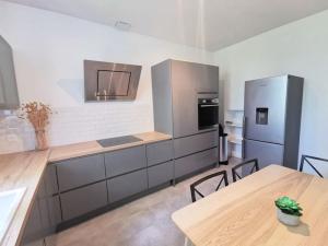 una cocina con electrodomésticos de acero inoxidable y mesas de madera en Nouveau - Au bout du quai en Nantes