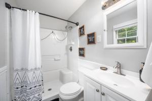 ein weißes Badezimmer mit Toilette und Waschbecken in der Unterkunft Pet Friendly Cozy 3BRM fully Fenced yard in Durham + 51 Fotos
