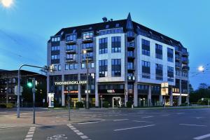 un grand bâtiment au coin d'une rue dans l'établissement SAXX Apartments Leipzig, à Leipzig