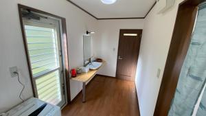 Kogushiにあるゼロベース下関室津の洗面台、デスク、窓が備わる客室です。