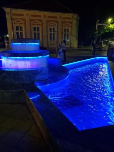 a pool with blue lights in front of a building at LENA Apartman 45m2 Sokobanja-CENTAR in Soko Banja