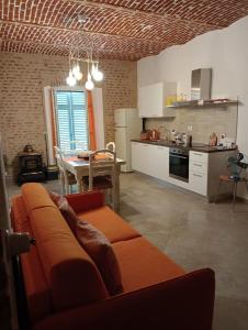 a living room with an orange couch and a kitchen at Appartamento Cico in Andezeno