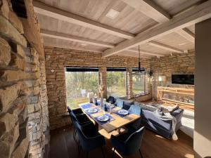 a dining room with a table and a stone wall at Kadakamarja (Juniper) Residence 