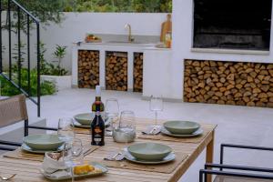 a wooden table with plates and wine glasses on it at Luxury Villa Del Sogno with pool, jacuzzi, parking in Trogir