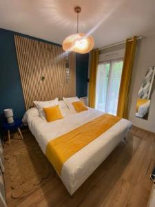 a bedroom with a large bed and a chandelier at Bonsaï Disneyland JO Paris 2024 avec Parking in Bailly-Romainvilliers