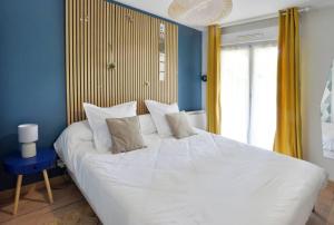 a bedroom with a large white bed with blue walls at Bonsaï Disneyland JO Paris 2024 avec Parking in Bailly-Romainvilliers