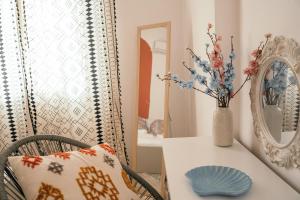 une salle à manger avec une table et un vase fleuri dans l'établissement Villager's Art Apartment, à Paradeísion