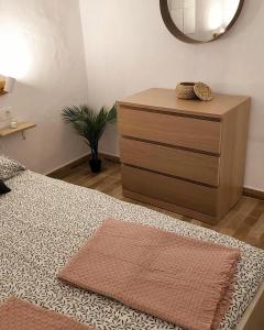 a bedroom with a dresser and a bed with a mirror at Villa MIA 2.0 in Giniginámar