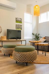 a living room with two chairs and a tv at Miombo Mews in Victoria Falls