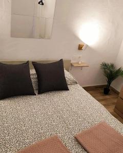 sypialnia z dużym łóżkiem z poduszkami w obiekcie Villa MIA 2.0 w mieście Giniginámar
