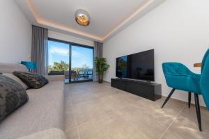 a living room with a couch and a flat screen tv at Apartman SeaSide 8 in Banjole