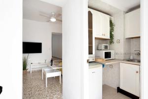 a kitchen with white cabinets and a dining room at Casa Rincón del Beso in Vejer de la Frontera