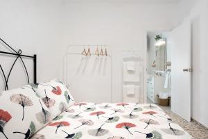 Un dormitorio con una cama con sombrillas. en Casa Rincón del Beso en Vejer de la Frontera