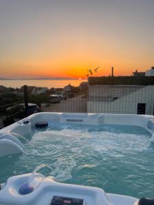 einen Whirlpool mit Sonnenuntergang im Hintergrund in der Unterkunft Vila Maričić in Sveti Petar