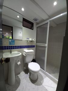 uma casa de banho com um WC, um chuveiro e um lavatório. em Hotel Quinta Avenida em Medellín