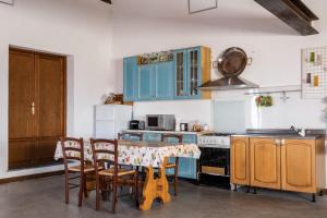 Canino的住宿－Casale di Primula Rossa，厨房配有蓝色橱柜和桌椅