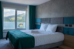 - une chambre avec un grand lit et une grande fenêtre dans l'établissement Hotel Plutitor Lebăda, à Bicaz