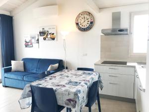 uma sala de estar com uma mesa e um sofá azul em Affittimoderni Castelsardo Smeralda CSSM16 em Castelsardo
