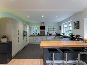 eine große Küche mit weißen Schränken und einer Holztheke in der Unterkunft Pass the Keys Gorgeous Central House in Bournemouth