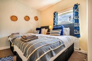 a bedroom with a large bed with blue and white sheets at Finest Retreats - George Street in Grantham