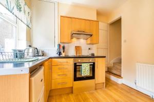 cocina con armarios de madera y horno en Finest Retreats - George Street en Grantham