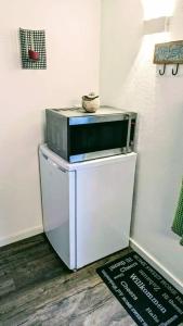a microwave sitting on top of a refrigerator at private gemütliche Einliegerwohnung in Enkenbach-Alsenborn