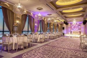 um salão de banquetes com mesas, cadeiras e lustres em Harir Palace Hotel em Amã