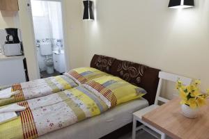 uma cama com uma colcha e uma mesa num quarto em Boros Vendégház em Bogács
