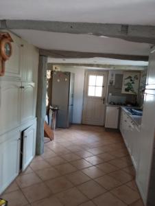 a kitchen with white cabinets and a tile floor at Maison de village in Sourribes