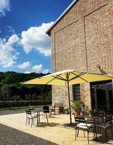 a yellow umbrella on a patio with tables and chairs at Agriturismo I Tre Colli in Viazzano