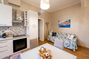 uma cozinha e uma sala de estar com um sofá em Casa Solemare em Savona
