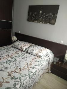 1 dormitorio con 1 cama con edredón de flores en Apartamento Casa Labaro, junto al Parque de Cabárceno, en Arenal