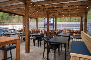 a restaurant patio with tables and chairs and lights at The Fernhurst by Greene King Inns in Blackburn