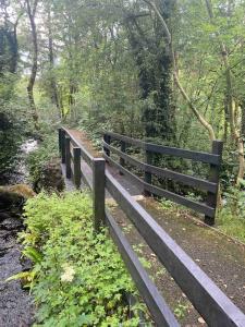 a wooden fence on a path in a forest at Beautiful 3 Bedroom House in Coolaney Village County Sligo 