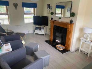 uma sala de estar com lareira e televisão em Beautiful 3 Bedroom House in Coolaney Village County Sligo 