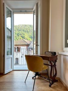 einen Schreibtisch und einen Stuhl in einem Zimmer mit Fenster in der Unterkunft Plaza Apartment in Cannobio