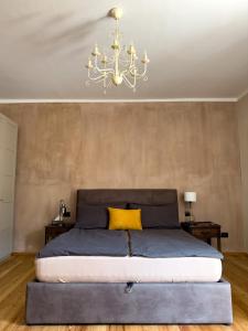 a bedroom with a large bed and a chandelier at Plaza Apartment in Cannobio