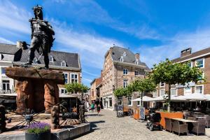 Eine Statue eines Mannes, der in einer Straße steht. in der Unterkunft Viator Holidayhome in Tongeren