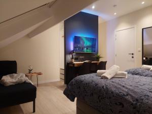 una camera con 2 letti, una scrivania e una TV di Viator Holidayhome a Tongeren