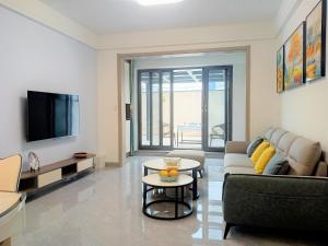 Una sala de estar con un sofá y un televisor. en Tao's Inn Guiyang, en Longli