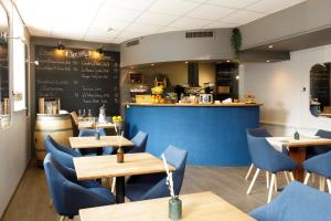 a restaurant with blue chairs and tables and a counter at Hôtel de l'Ange in Nyon