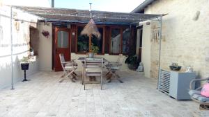 eine Terrasse mit einem Tisch und Stühlen darauf in der Unterkunft Chambre d'hôtes Les Nénuphars in Melle