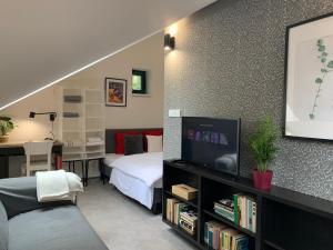 a bedroom with a bed and a desk with a tv at Cozy friendly place with free parking in Prague