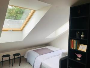 1 dormitorio en el ático con cama y ventana en Cozy friendly place with free parking, en Praga