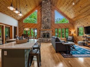 a large living room with a stone fireplace in a house at The Loonstar Lodge On Rabbit Lake in Crosby