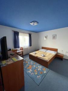 1 dormitorio con 1 cama grande y 1 mesa en Active Wellness hotel U zlaté rybky, en Vyškov